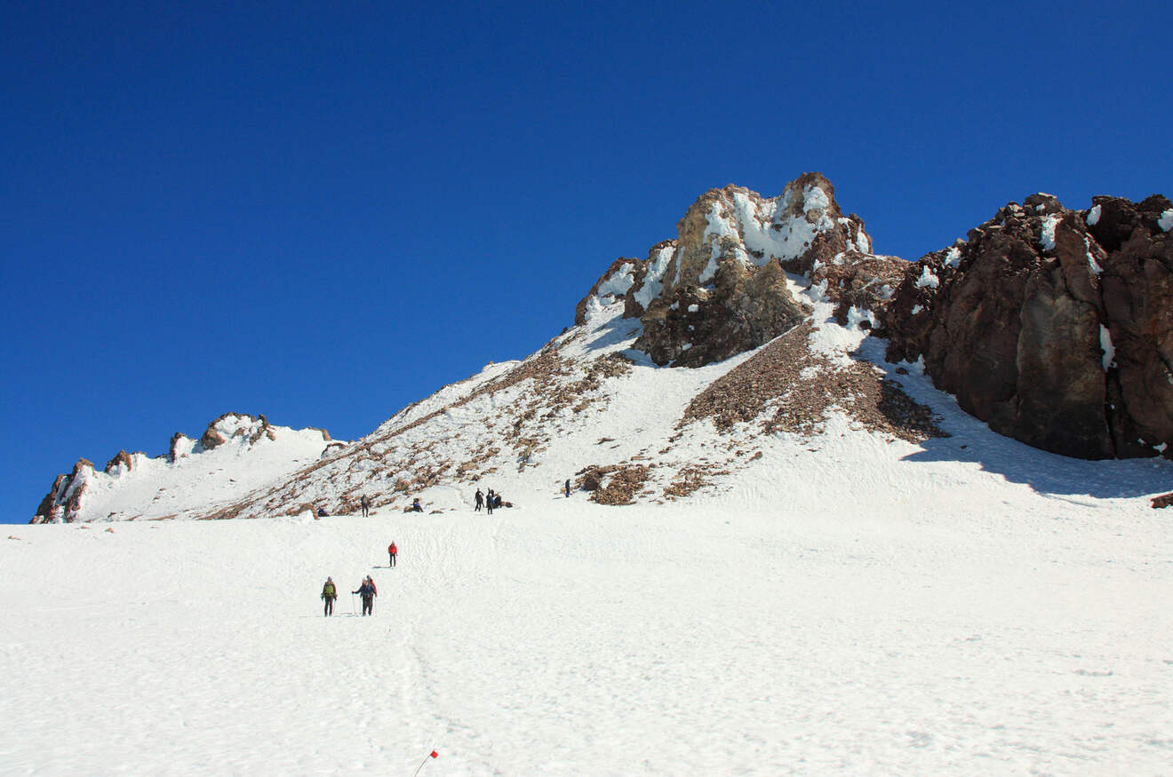 People climbing up a snowy mountain