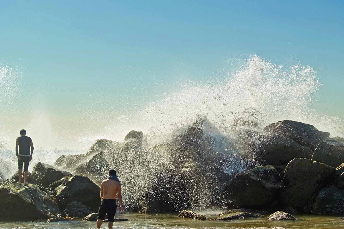 a man standing on top of a rock-covered beach