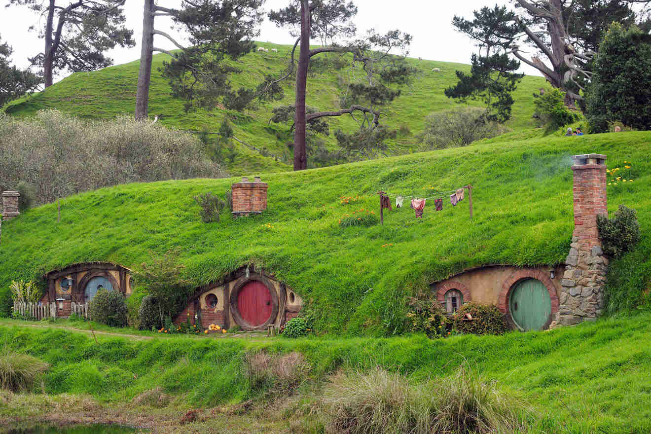a hobbit house with a green roof and a red door