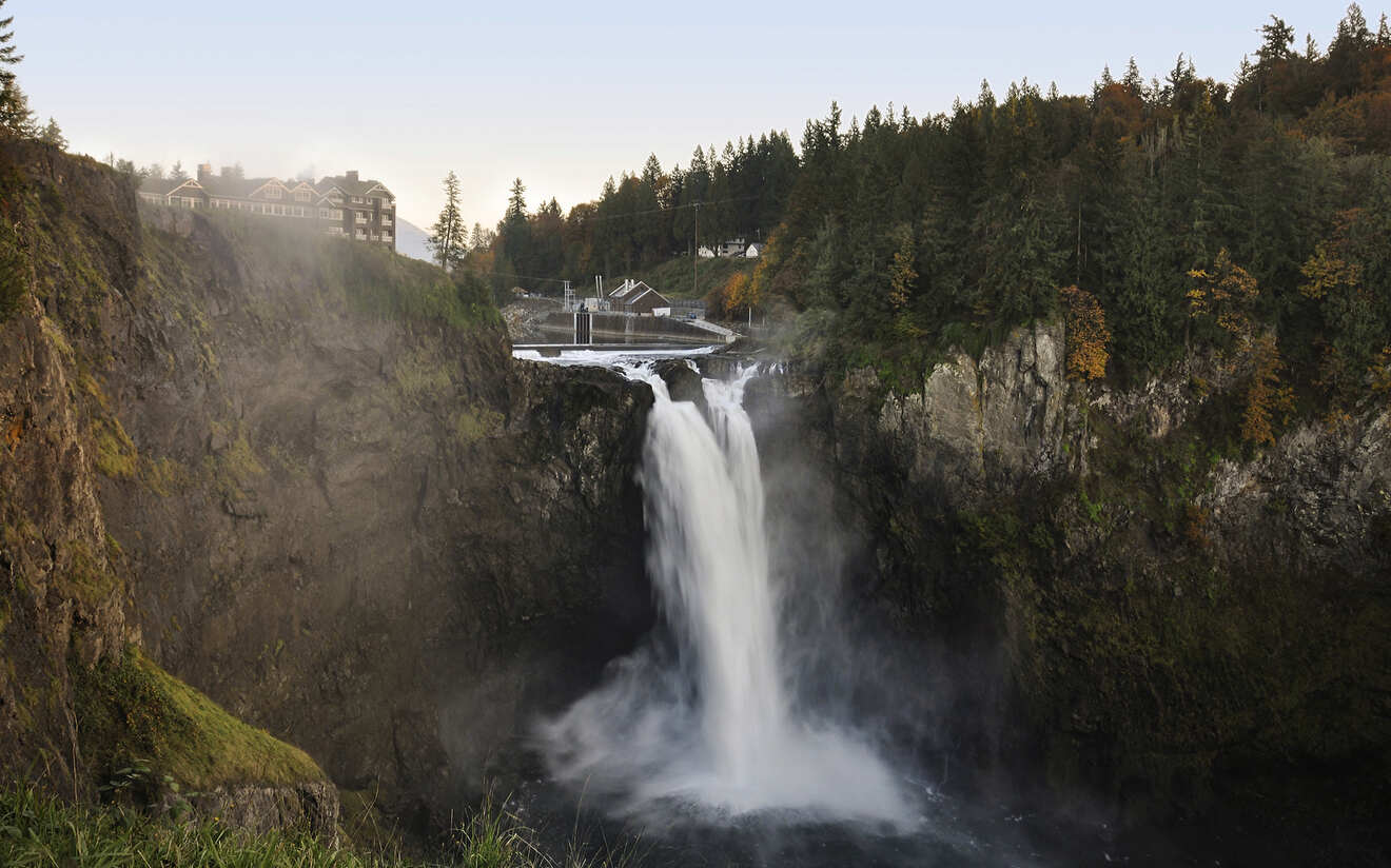 a waterfall with a bridge in the background