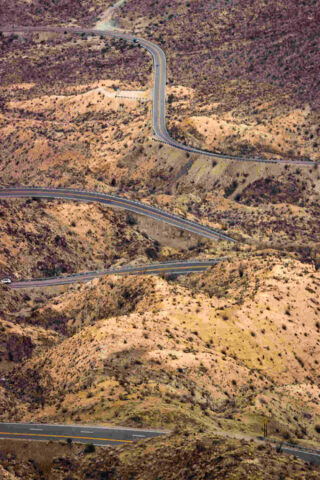 an aerial view of a winding road in the desert