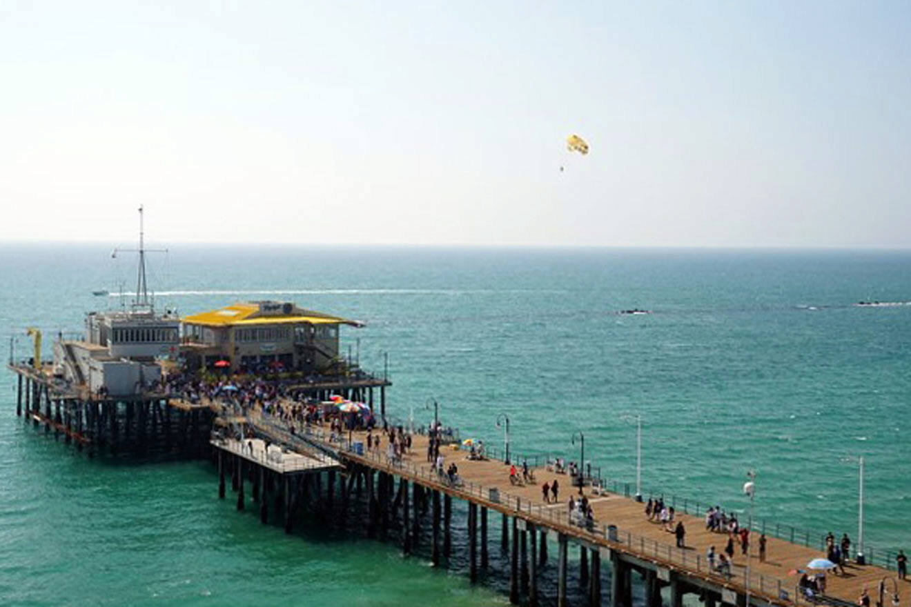 a pier on the ocean with people walking on it