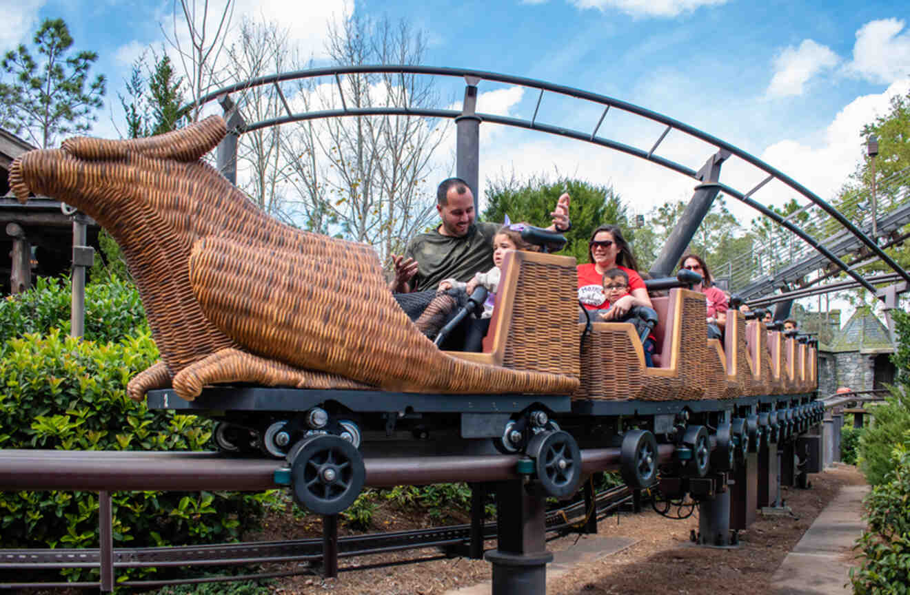 Adults and children riding on the Flight of the Hippogriff roller coaster