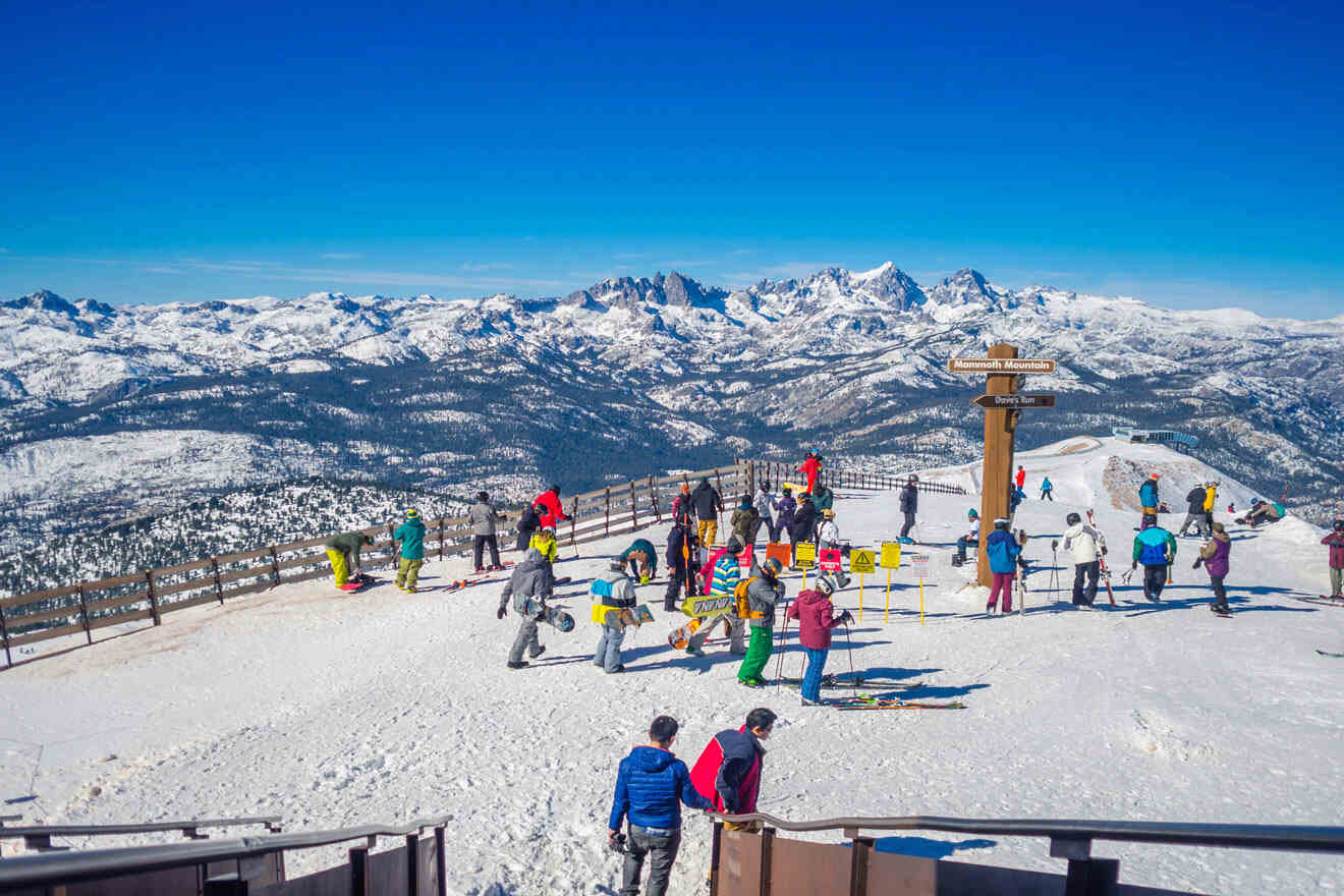 a group of people with skis and snowboards standing on top of a snowy slope