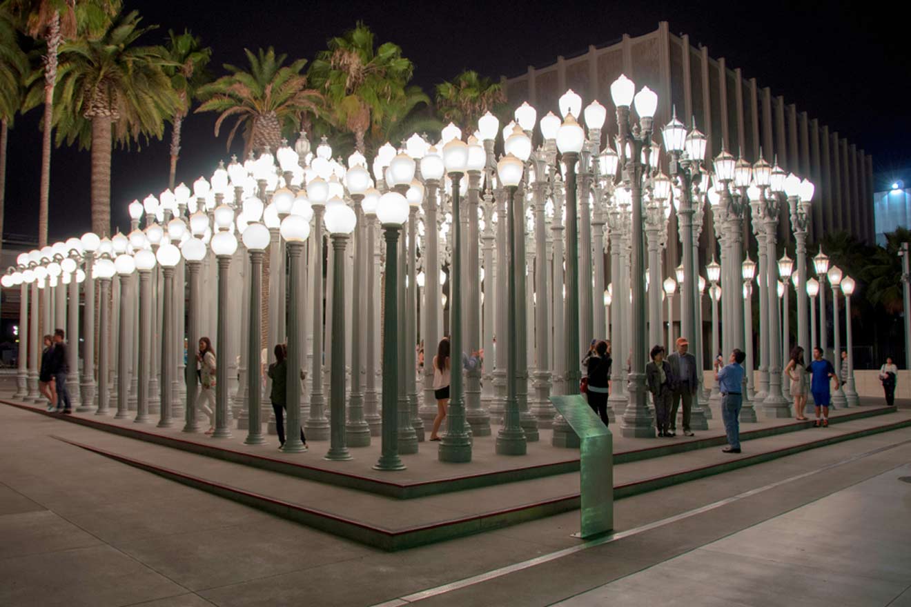 a group of people standing under a structure with lights