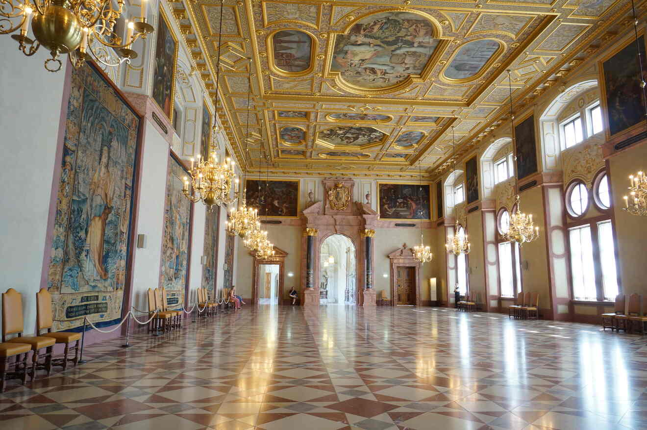 a large room with chandeliers and paintings on the walls