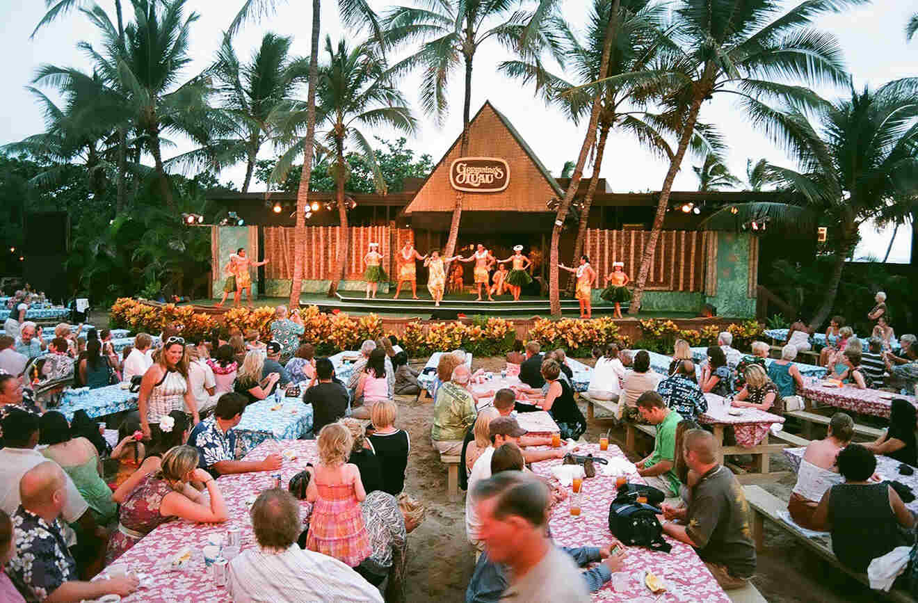People sitting at tables watching a show at Germaine's luau