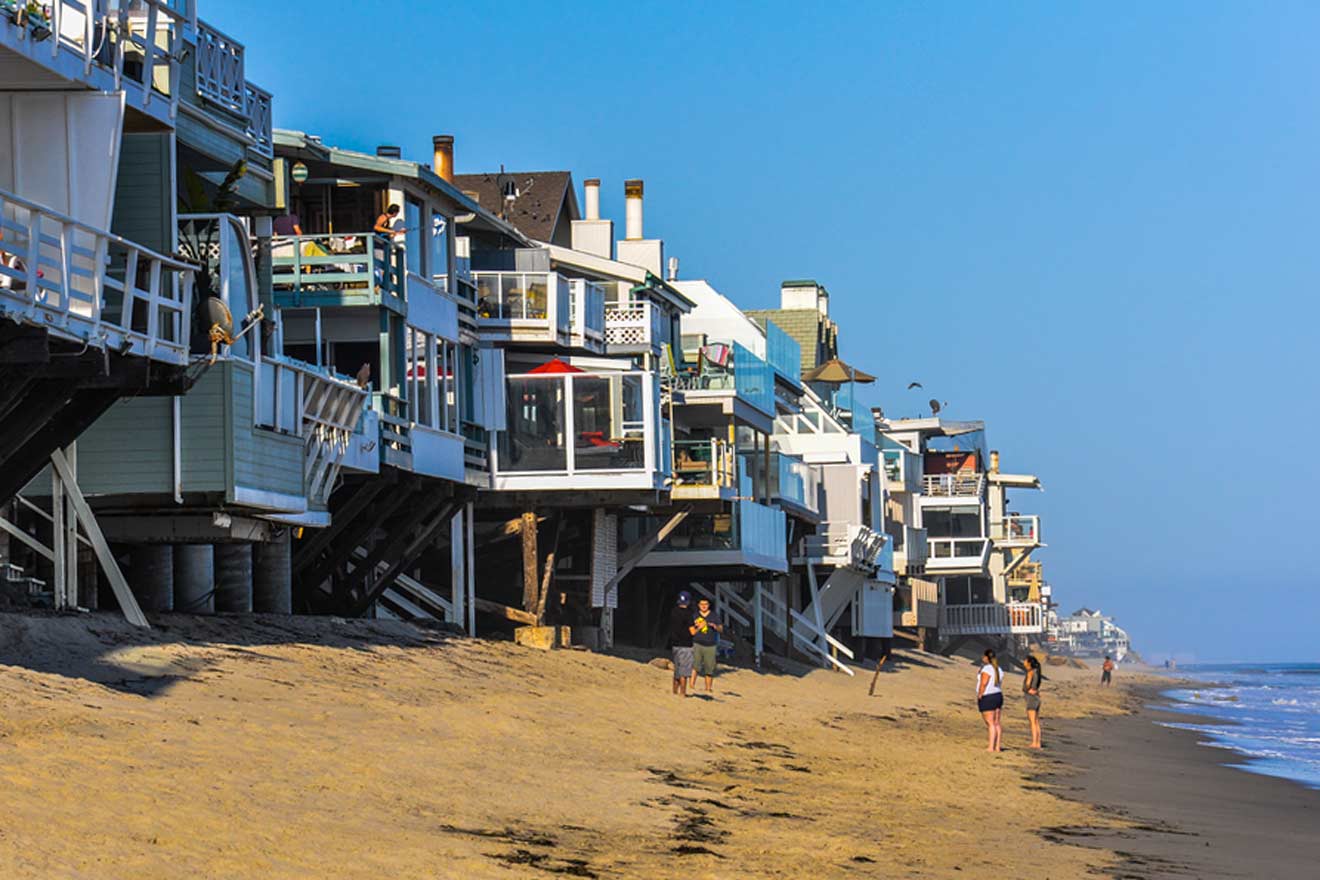 a row of houses on a beach next to the ocean
