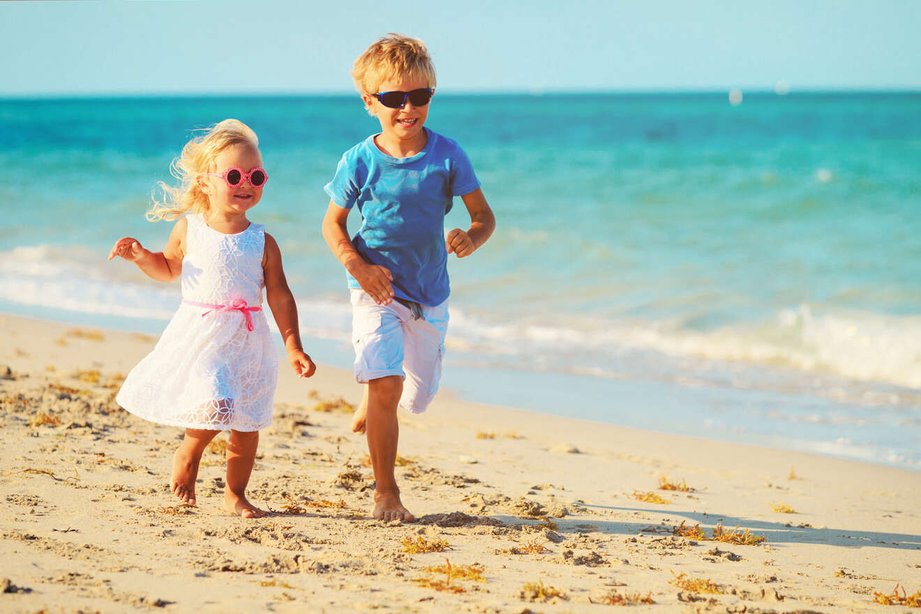 A girl and a boy running on the beach