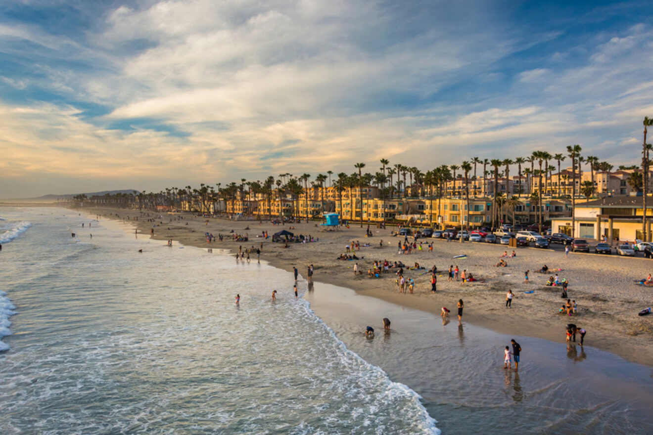 a beach with a lot of people on it at sunset