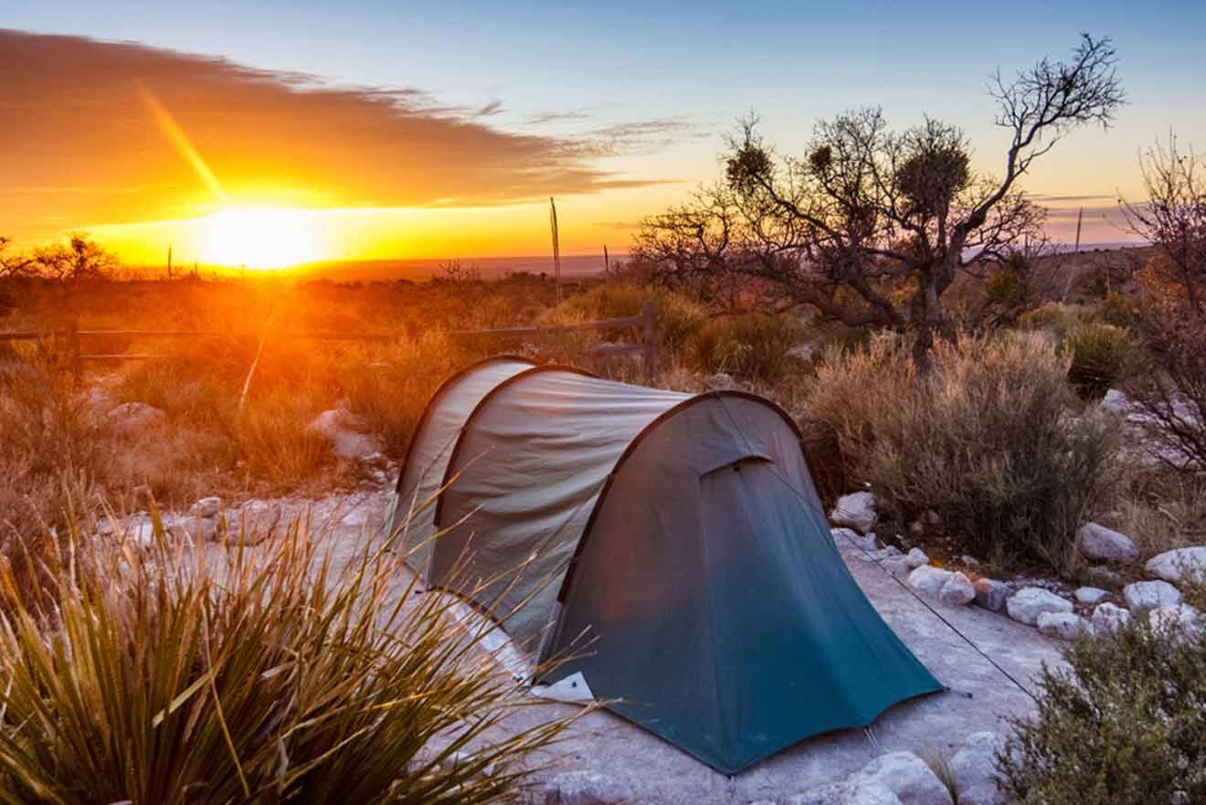 a tent pitched up in the desert at sunset