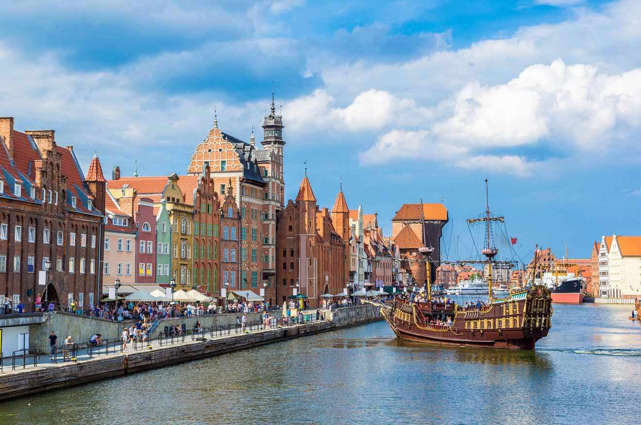 a touristic boat sailing down a river next to old town buildings