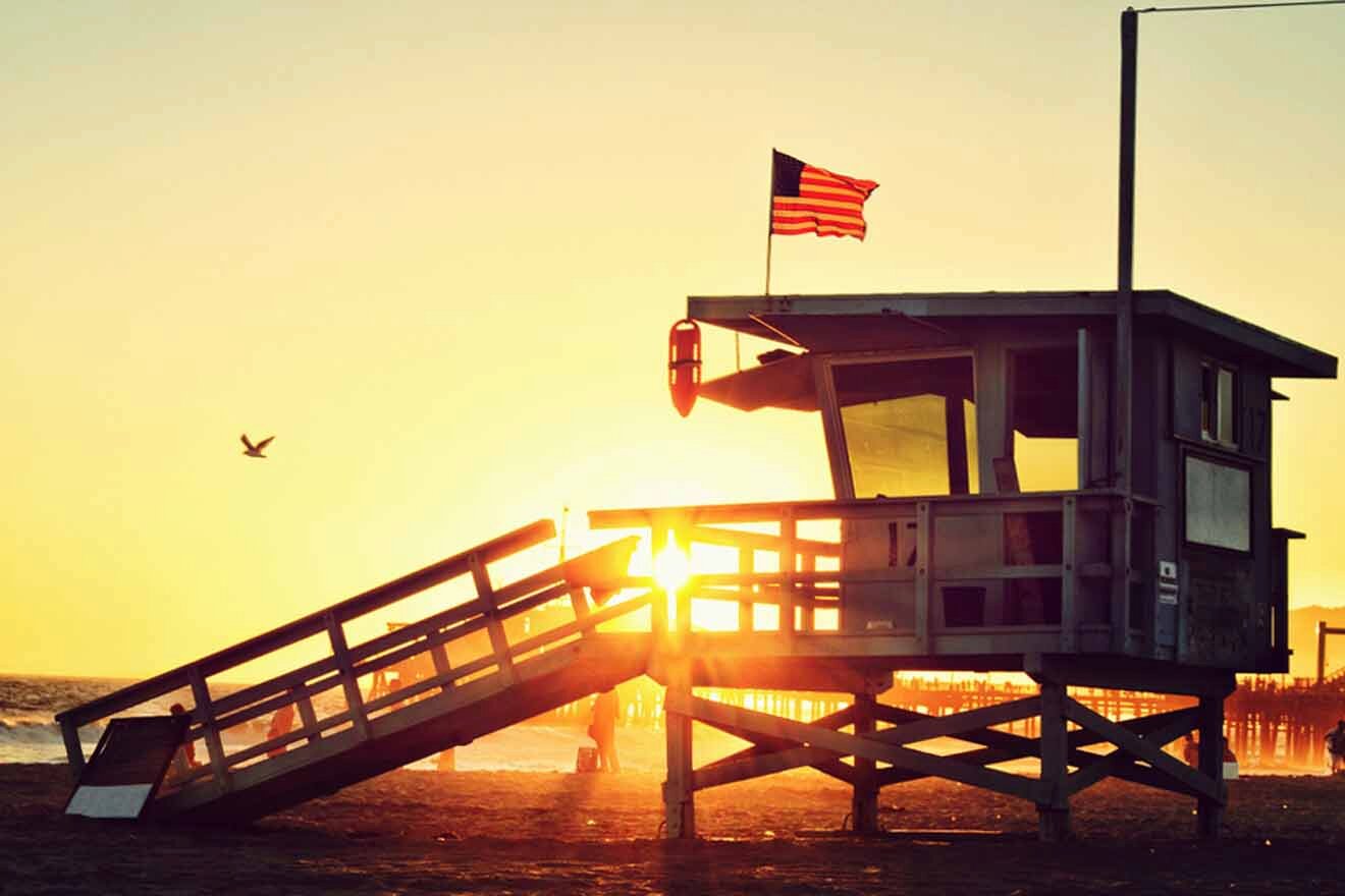 a lifeguard tower on a sandy beach at sunset