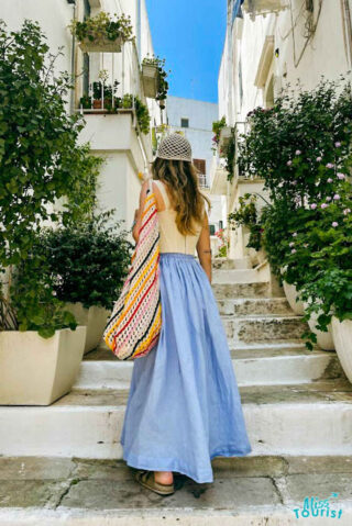 a woman in a blue skirt is walking up the stairs