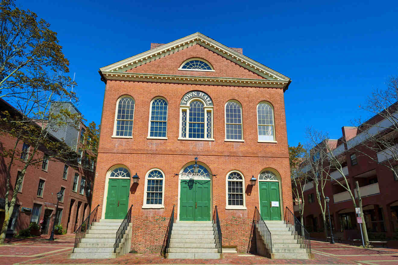 a red brick building with green doors and steps