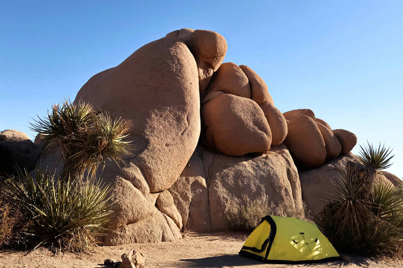 a tent pitched up against a rock formation