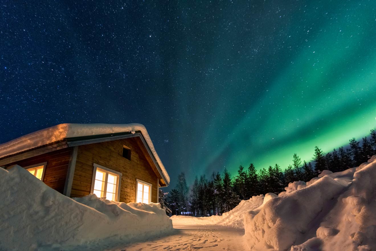 a cabin in the middle of a snow covered field and northern lights