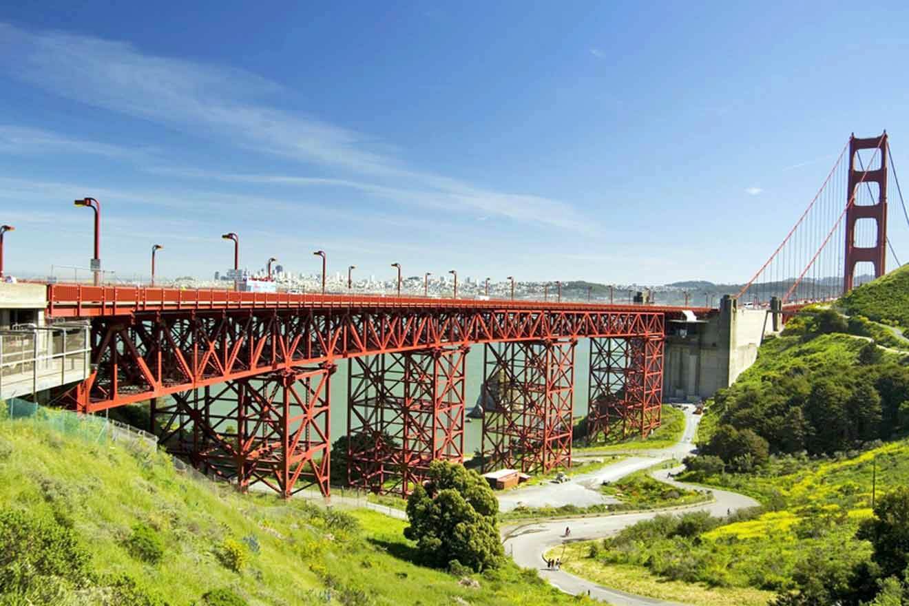 a large red bridge over a lush green hillside