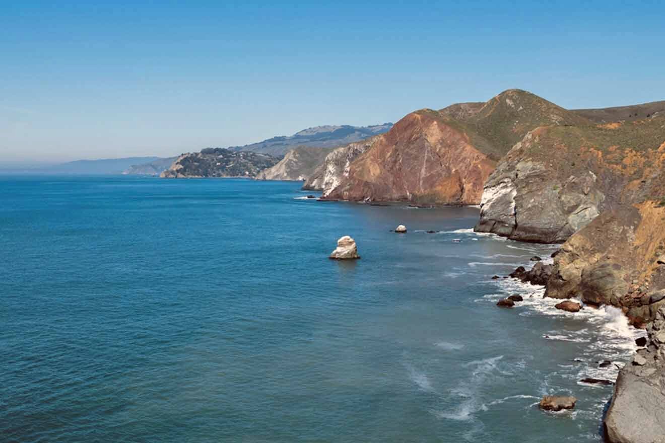 a body of water surrounded by mountains and rocks on a sunny day