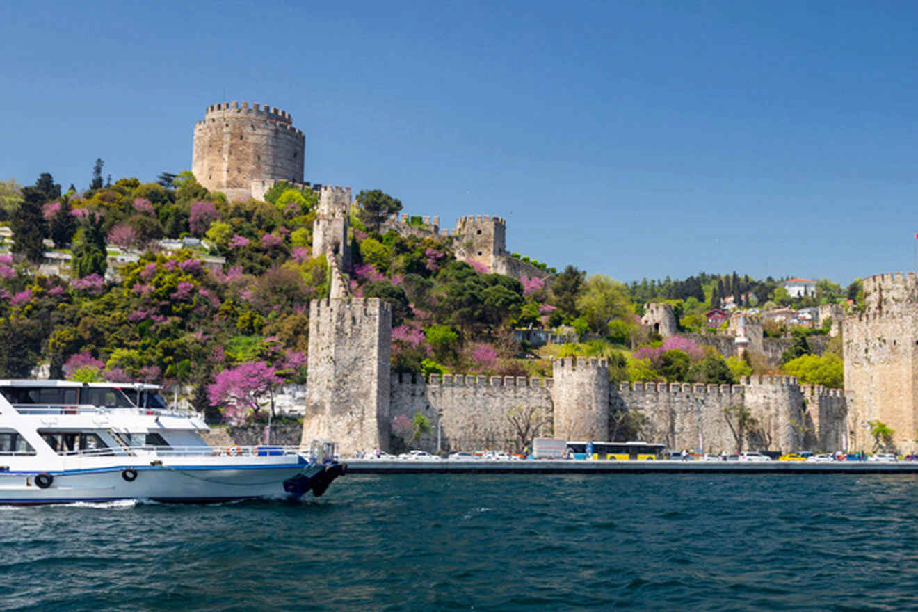 a boat in the water near a castle on a hill