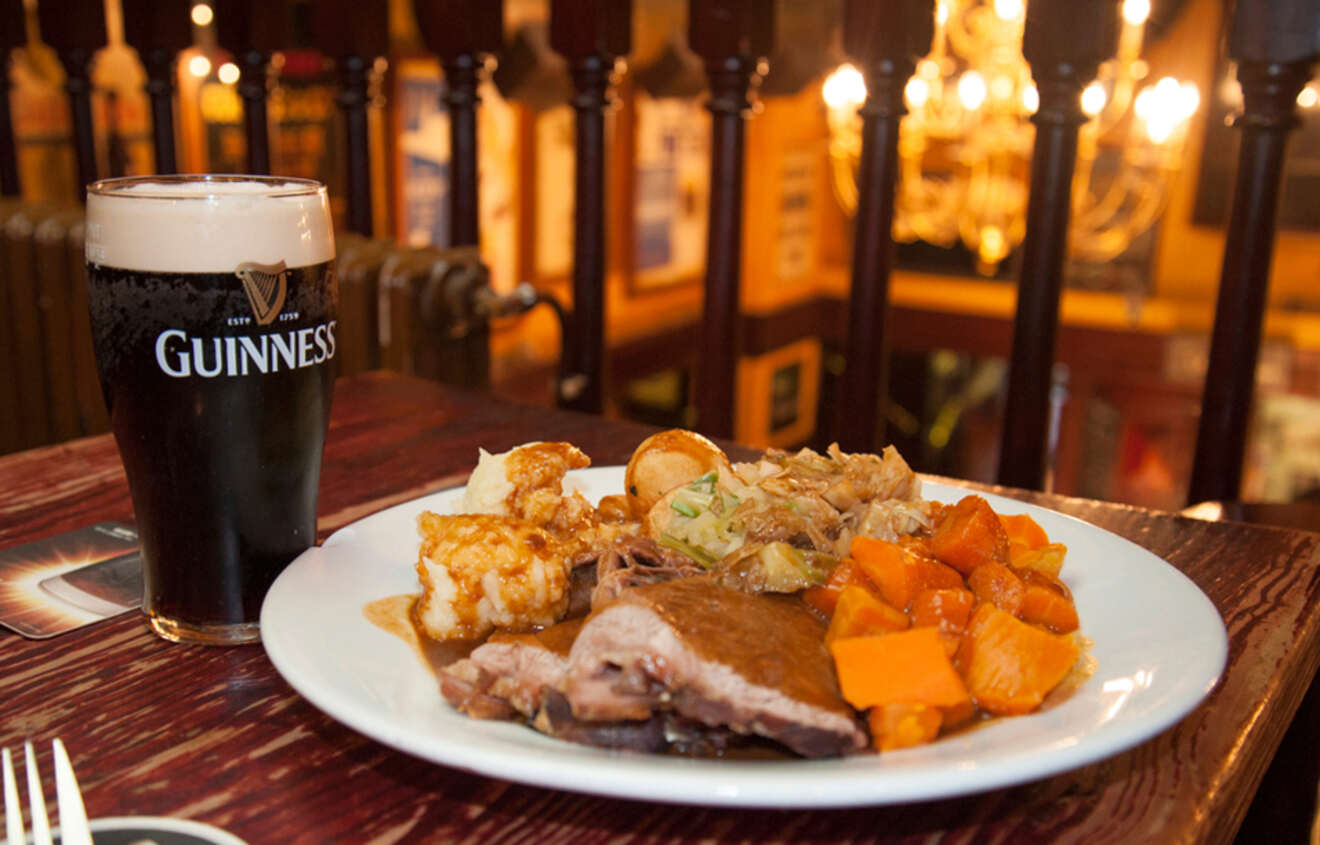 a plate of food and a glass of beer on a table