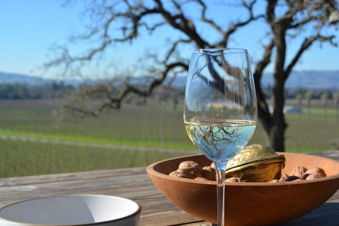 a glass of wine sitting on top of a wooden table