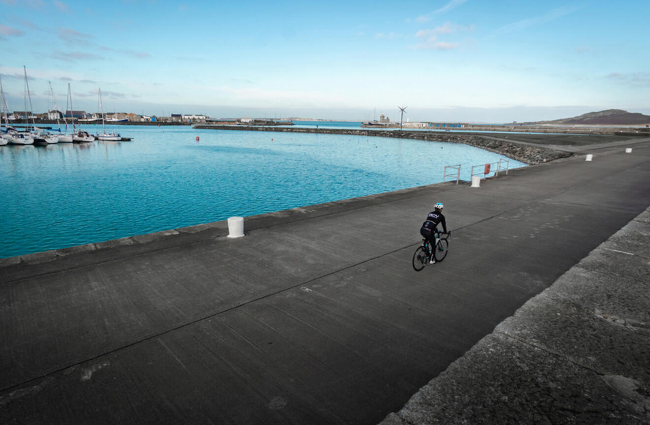 A person cycling along the coast towards Howth Lighthouse