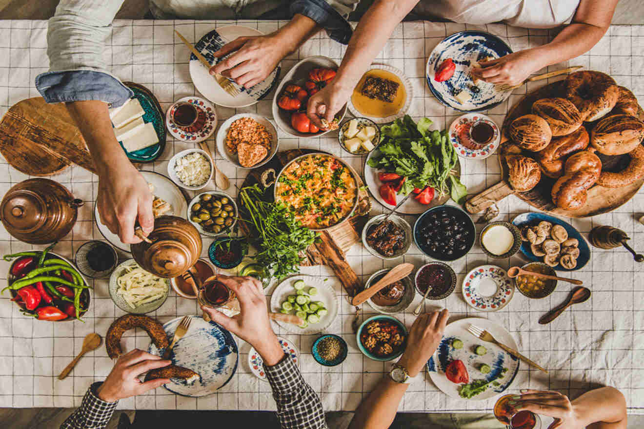 a flat lay of a table filled with food and group of people sitting around it
