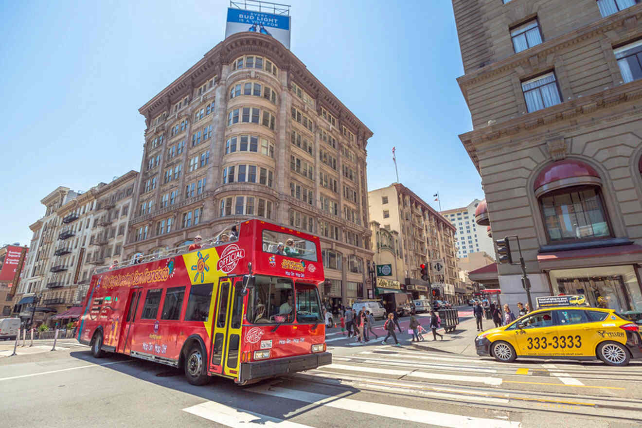 a red bus driving down a street next to tall buildings