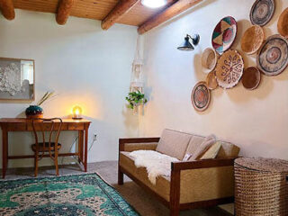 hotel's living room with a couch, desk and chair with lots of decorative pieces on the walls