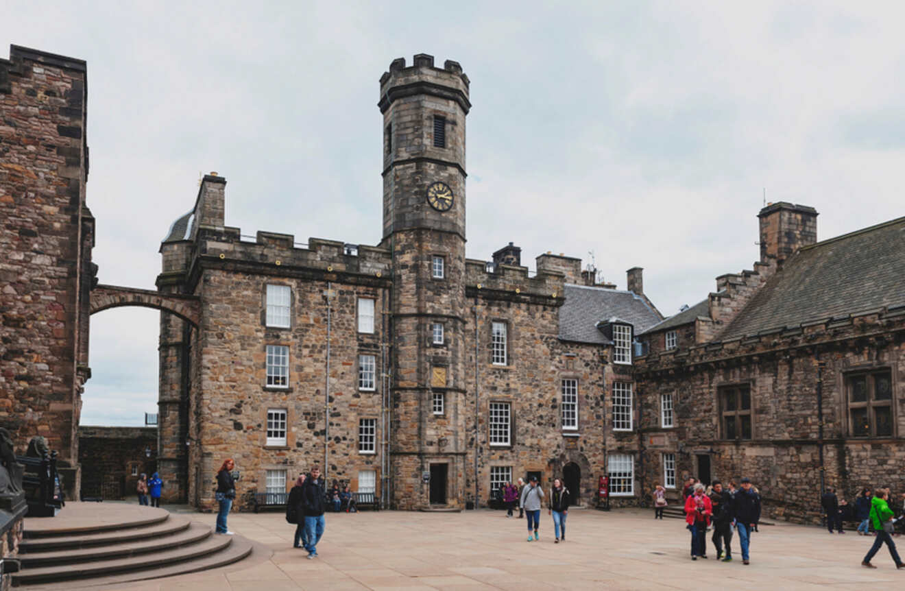 a group of people walking around a castle like building