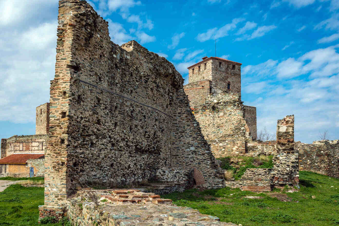 Stone ruins of an ancient fortress under a blue sky with scattered clouds.