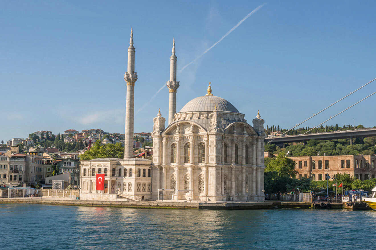 a mosque next to a river and a bridge