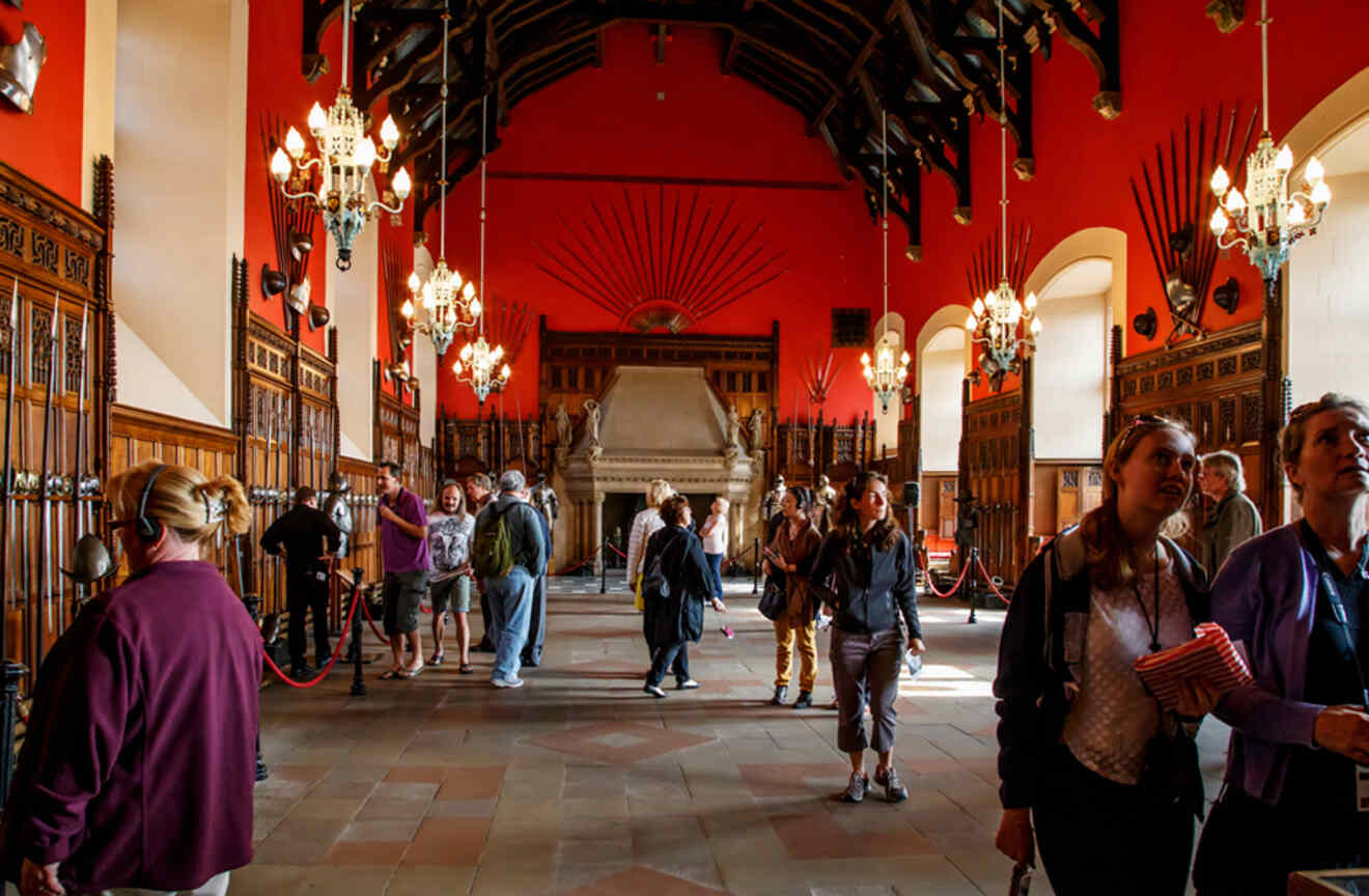 a group of people standing in a large castle room