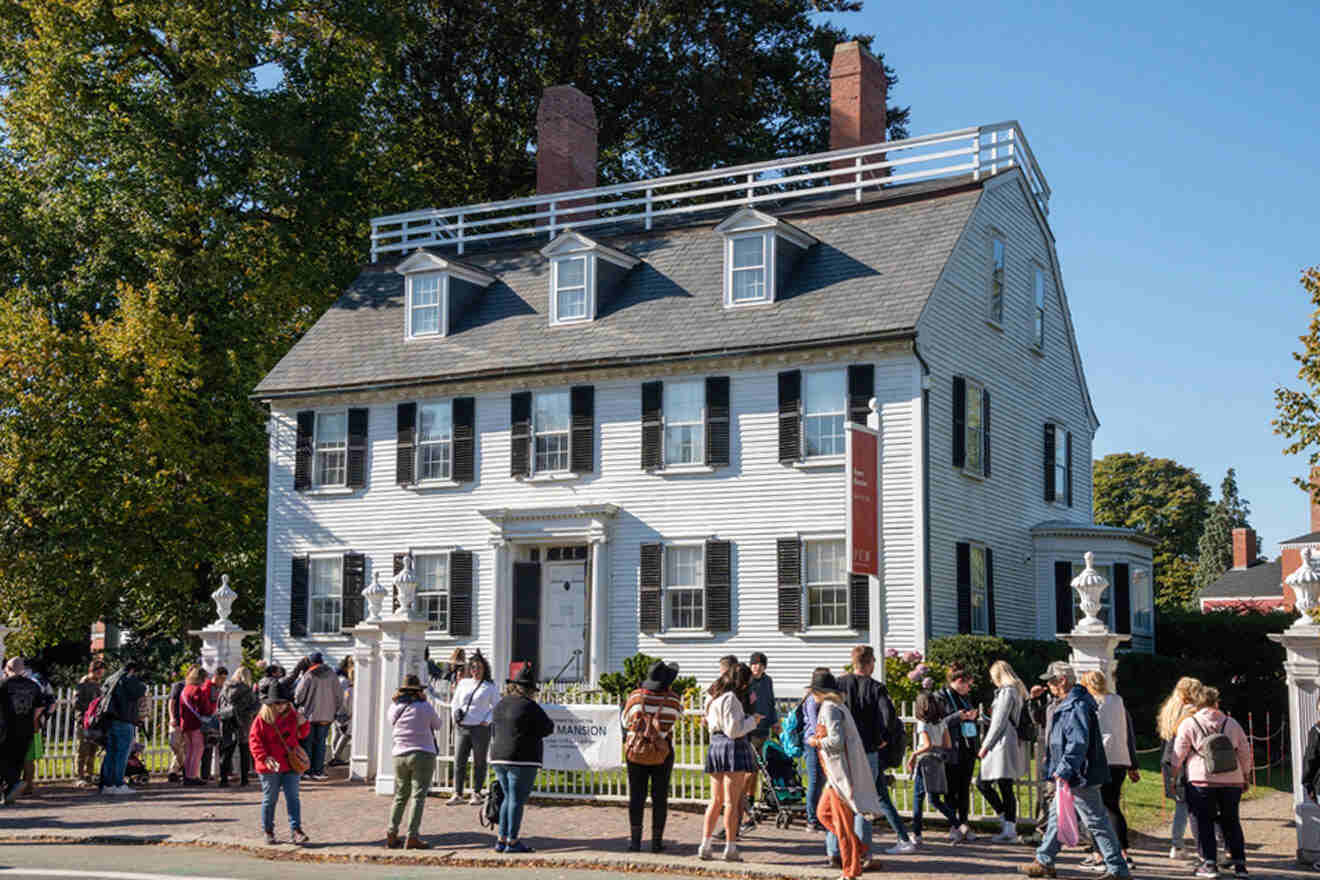 a group of people standing in front of a white house