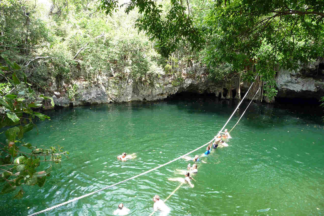 a group of people hanging from a rope over a body of water