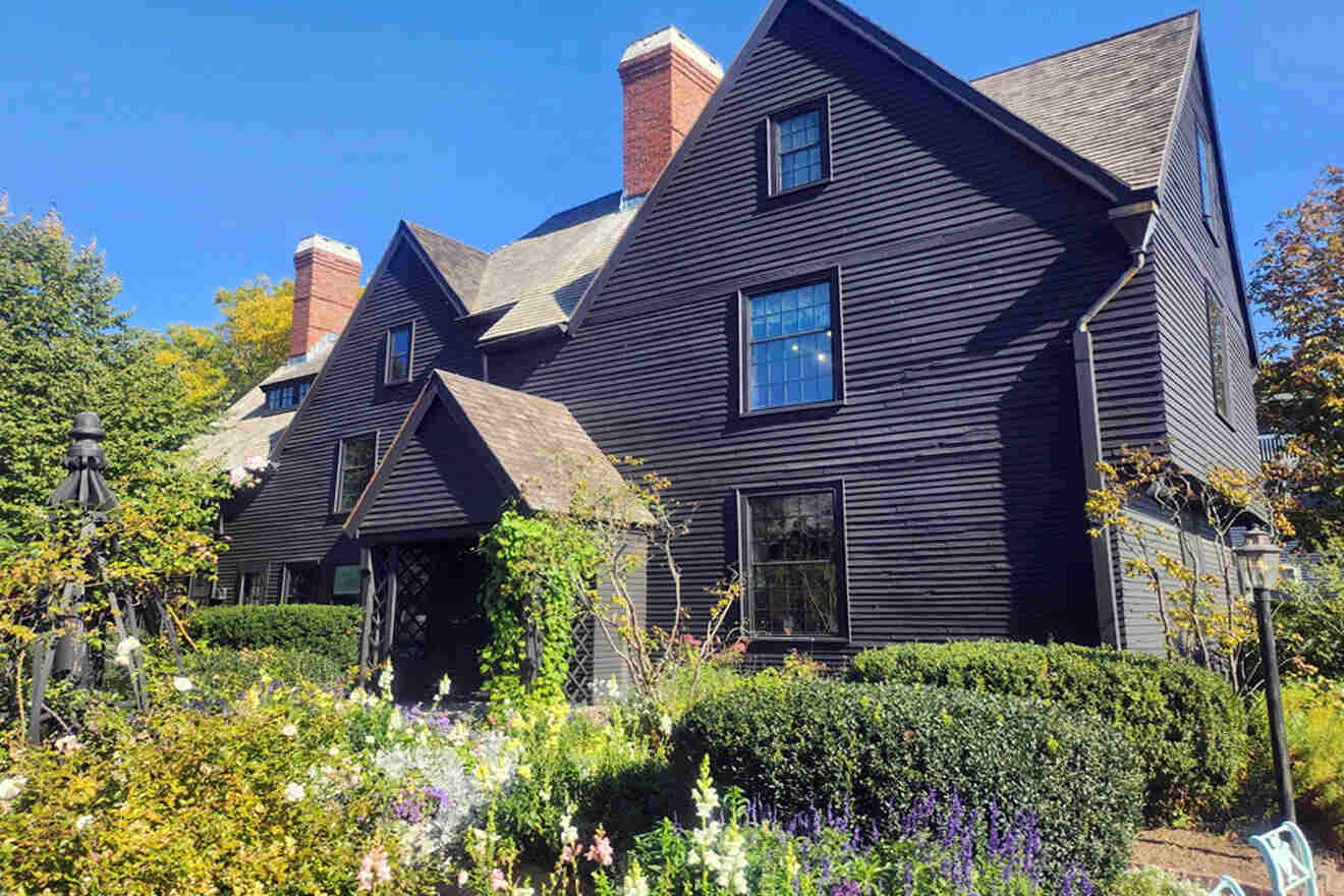 a large black house with a lot of flowers in front of it