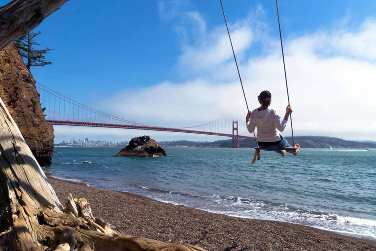 a man swinging on a rope near the ocean