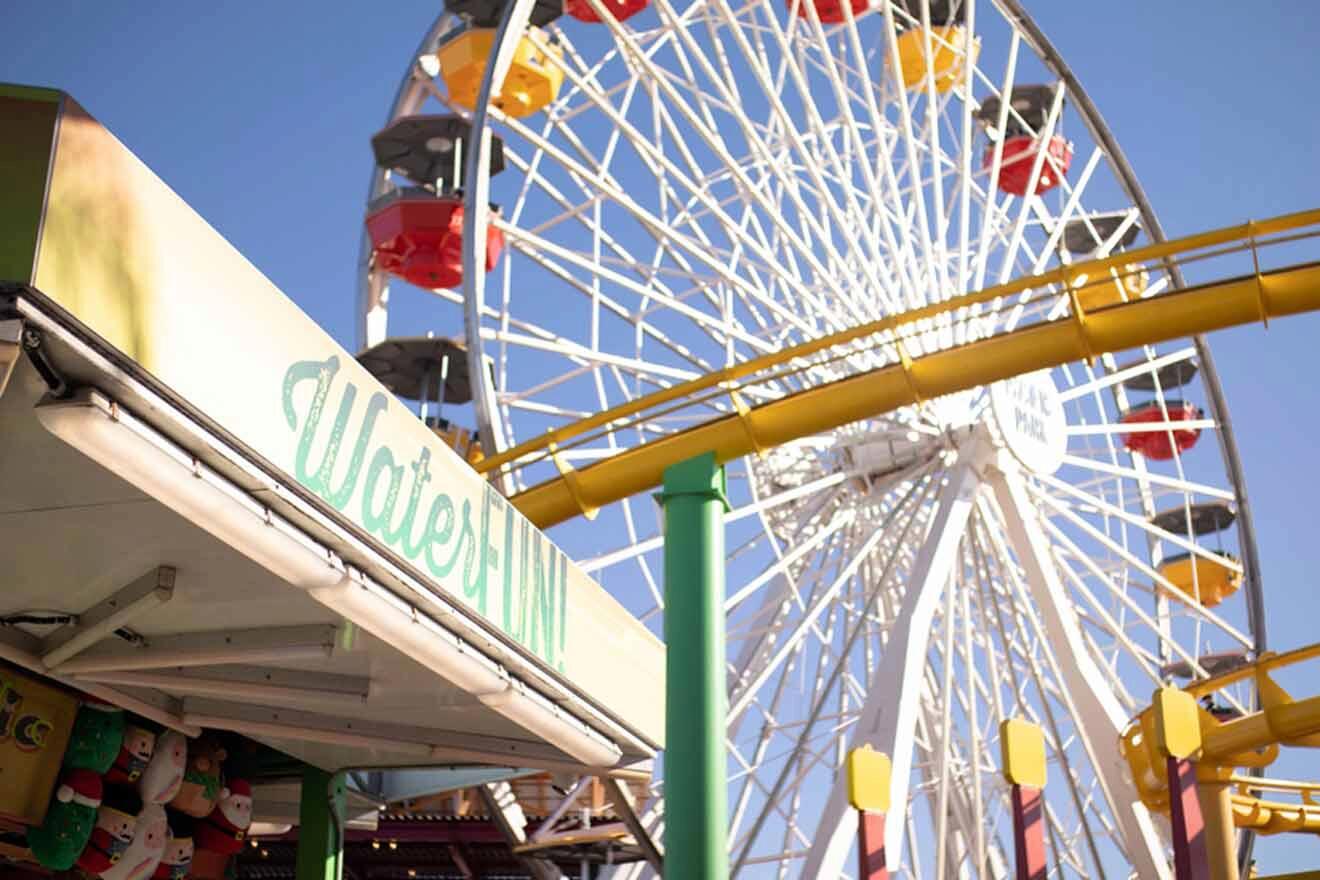 ferris wheel in a theme park with a amusement stand next to it