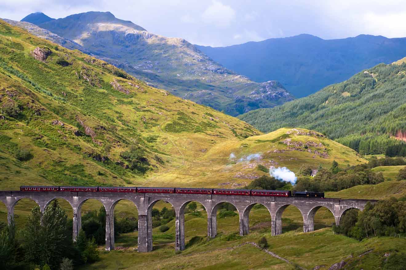 a train traveling over a bridge in the mountains