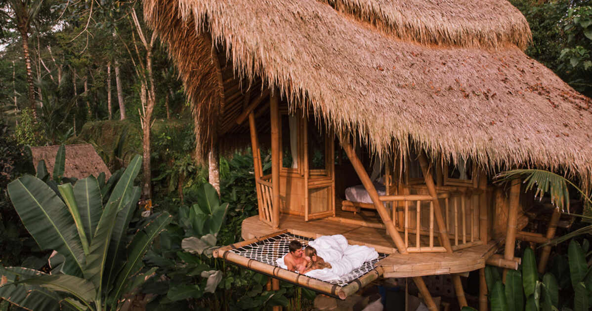 A couple hugging on a hammock in a bamboo house