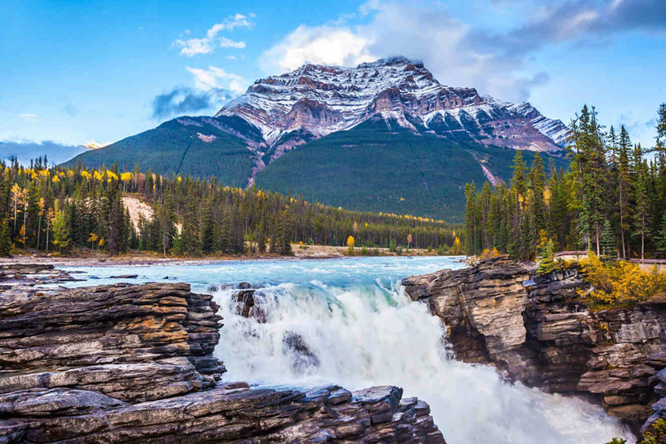 A captivating view of Jasper National Park in Canada, showcasing a majestic landscape of towering mountains and a mesmerizing waterfall at the center.