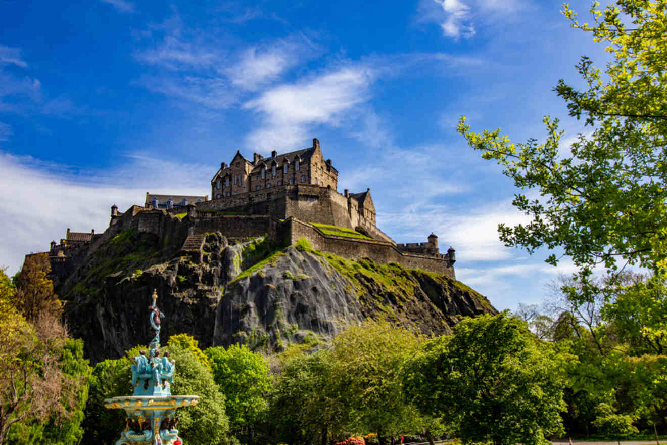 a castle on a hill with a fountain in the foreground