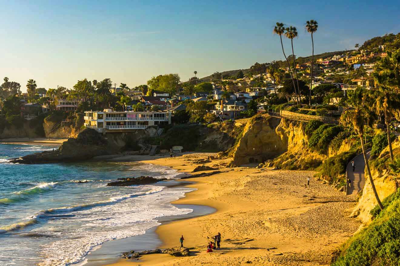 a view of a beach with houses on the cliff