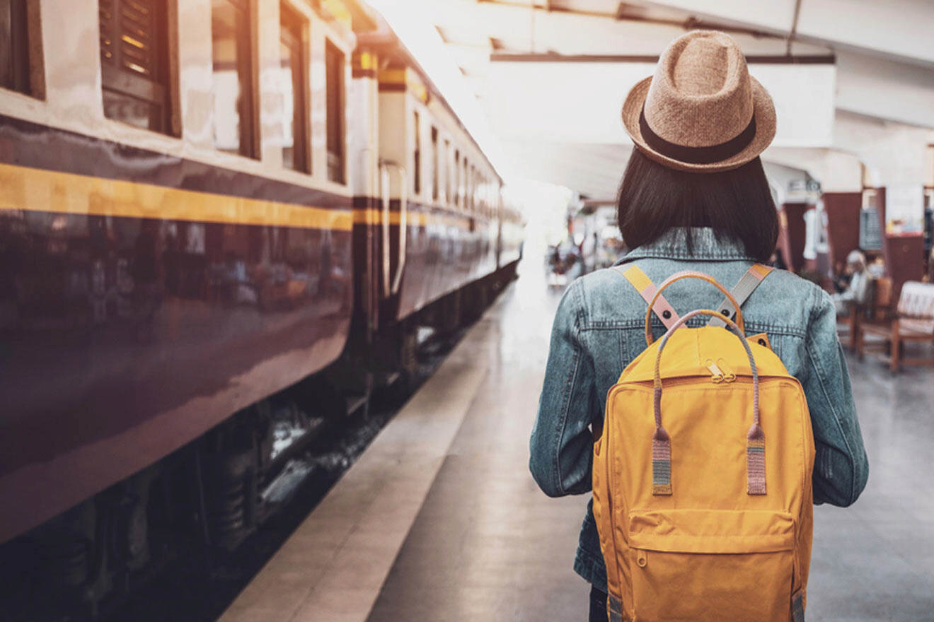 a person with a backpack walking towards a train