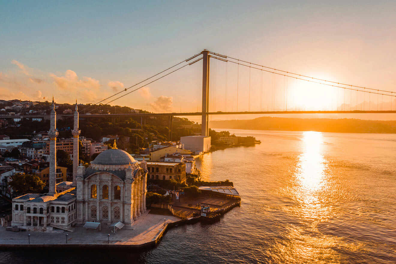 an aerial view of a mosque and a bridge over a body of water in the background on the sunset