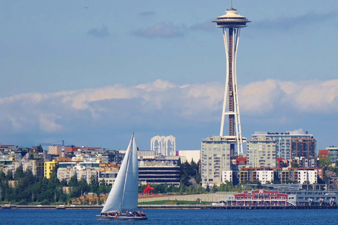 a sailboat in a body of water with a city in the background