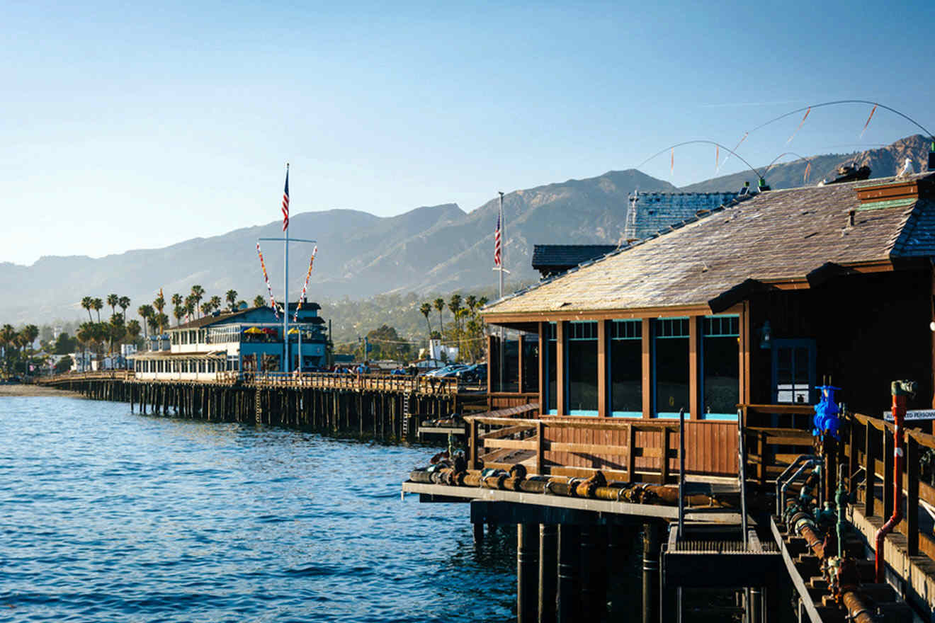 a pier with a boat in the water and mountains in the background