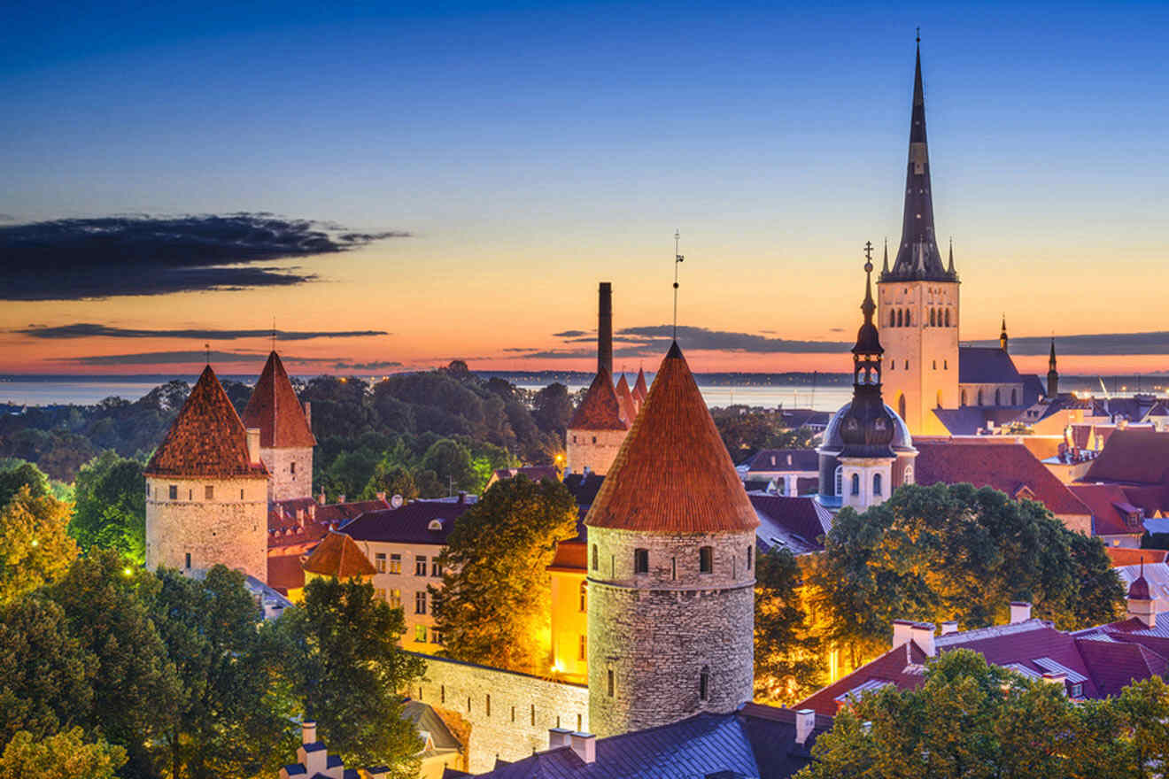 a view of a city at dusk with a church steeple in the background