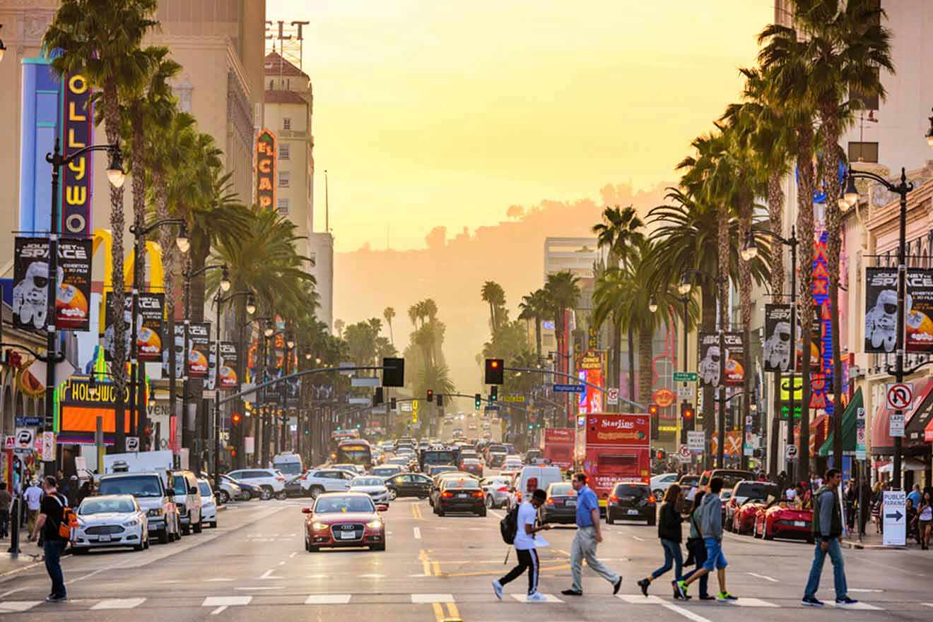 Hollywood Boulevard at sunset with palm trees, busy traffic, and iconic landmarks.